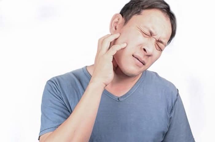 Patient experiencing tooth pain requiring emergency dental care in Kitchener